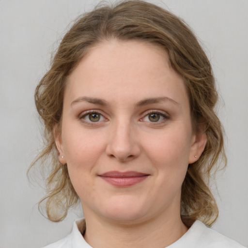 Joyful white young-adult female with medium  brown hair and green eyes