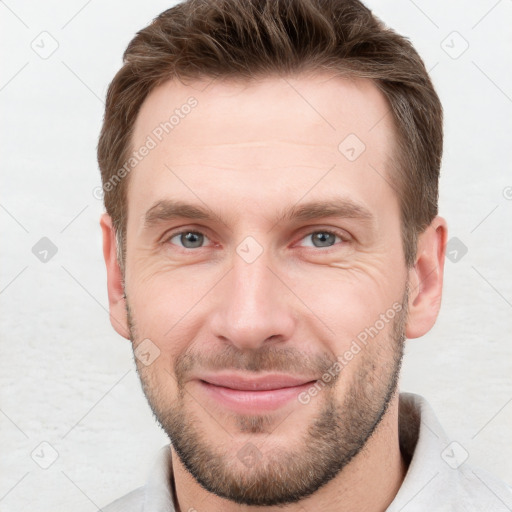 Joyful white young-adult male with short  brown hair and grey eyes