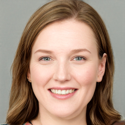 Joyful white young-adult female with long  brown hair and blue eyes