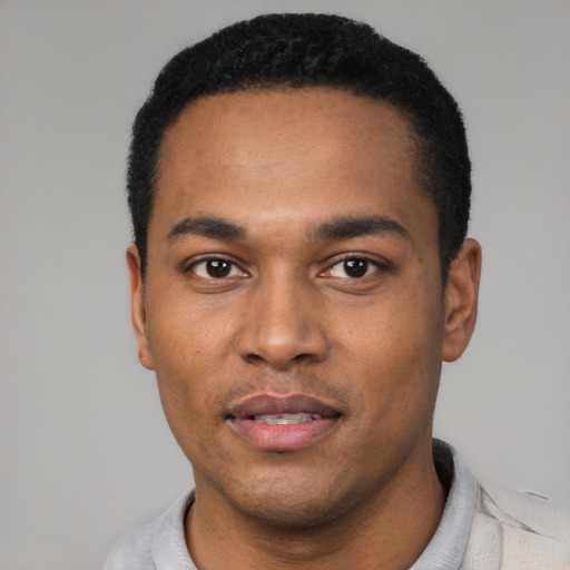 Joyful black young-adult male with short  black hair and brown eyes