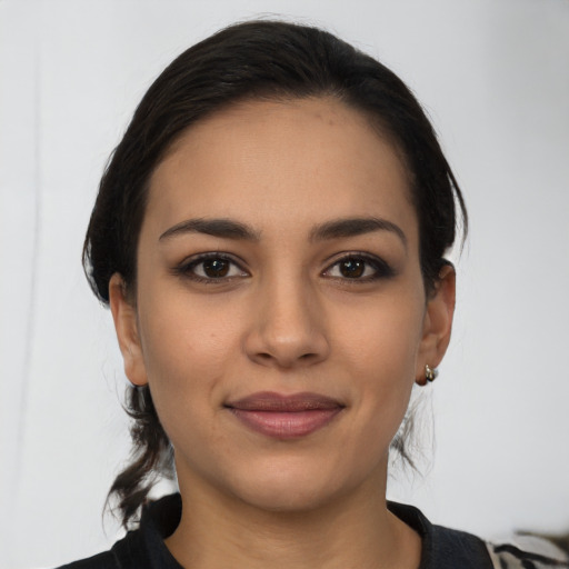 Joyful latino young-adult female with medium  brown hair and brown eyes