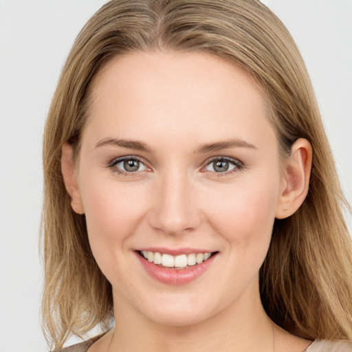 Joyful white young-adult female with long  brown hair and blue eyes