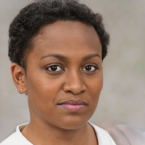 Joyful black young-adult female with short  brown hair and brown eyes