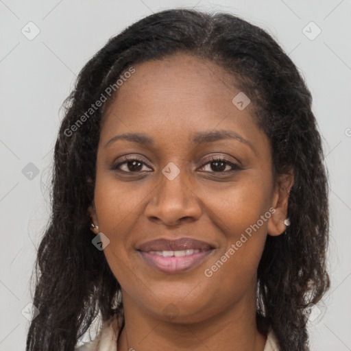 Joyful black young-adult female with long  brown hair and brown eyes