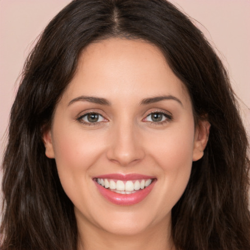 Joyful white young-adult female with long  brown hair and brown eyes