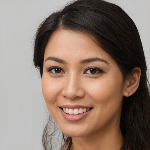 Joyful latino young-adult female with long  brown hair and brown eyes