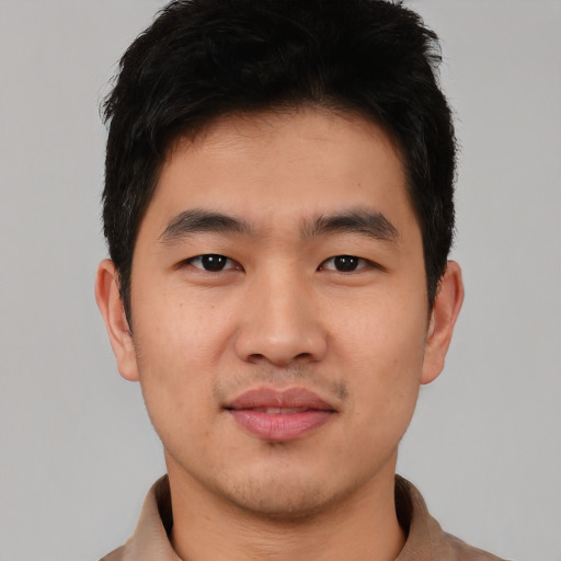 Joyful asian young-adult male with short  black hair and brown eyes