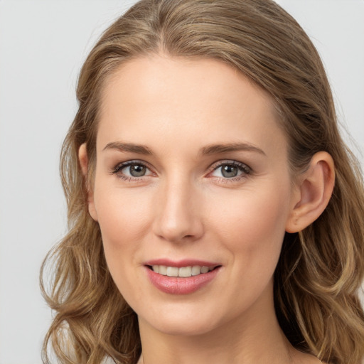 Joyful white young-adult female with long  brown hair and blue eyes