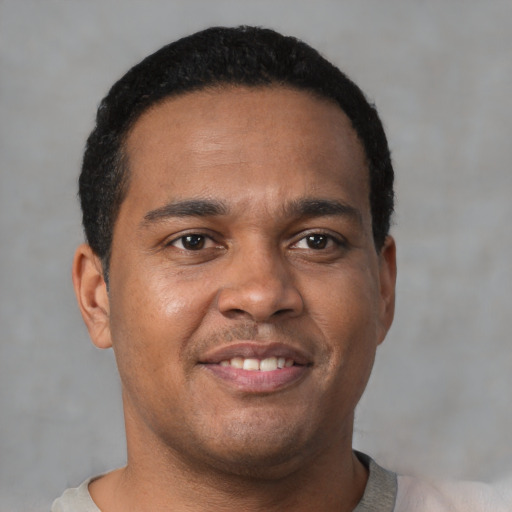 Joyful latino young-adult male with short  brown hair and brown eyes