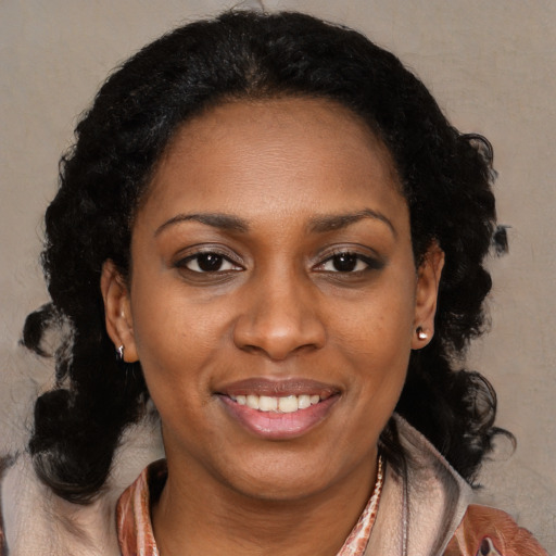 Joyful black adult female with medium  brown hair and brown eyes
