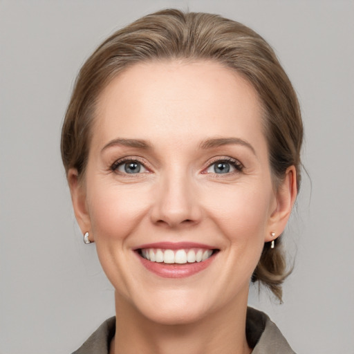 Joyful white young-adult female with medium  brown hair and grey eyes