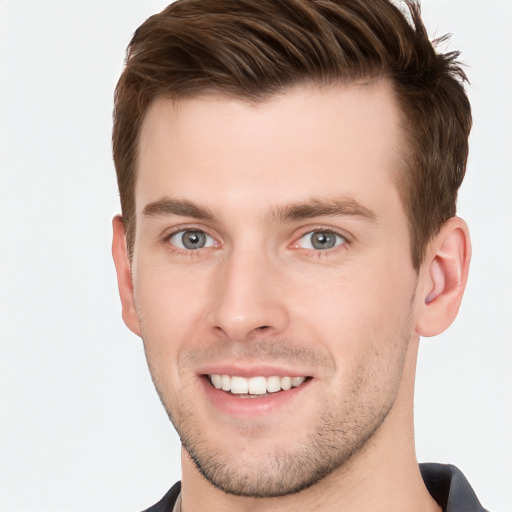 Joyful white young-adult male with short  brown hair and grey eyes