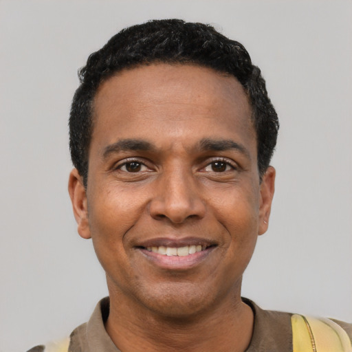 Joyful black young-adult male with short  black hair and brown eyes