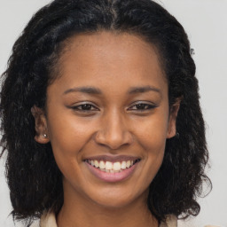 Joyful black young-adult female with long  brown hair and brown eyes