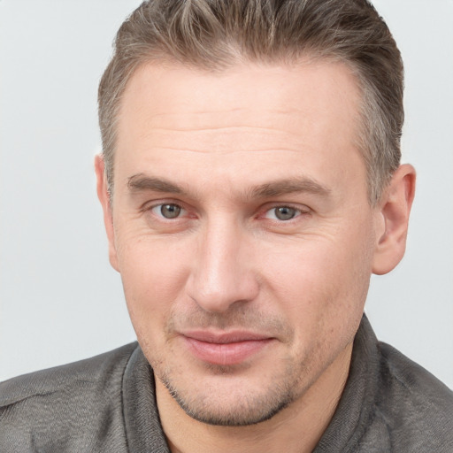 Joyful white adult male with short  brown hair and grey eyes