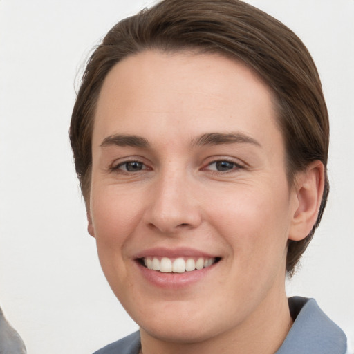 Joyful white young-adult female with short  brown hair and grey eyes