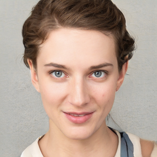 Joyful white young-adult female with short  brown hair and blue eyes