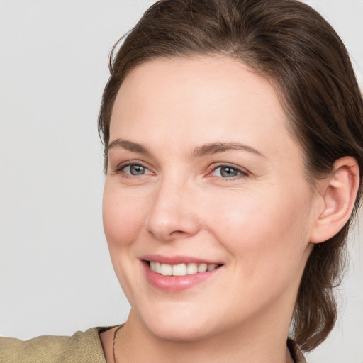 Joyful white young-adult female with medium  brown hair and grey eyes