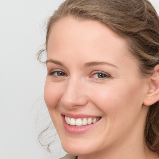 Joyful white young-adult female with medium  brown hair and blue eyes