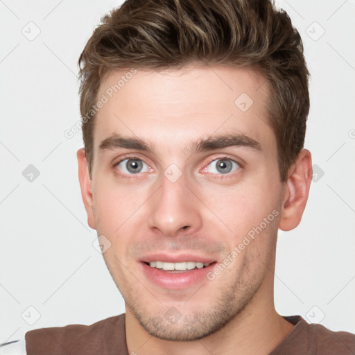 Joyful white young-adult male with short  brown hair and grey eyes