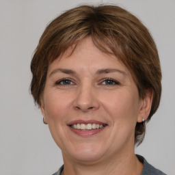 Joyful white adult female with medium  brown hair and grey eyes