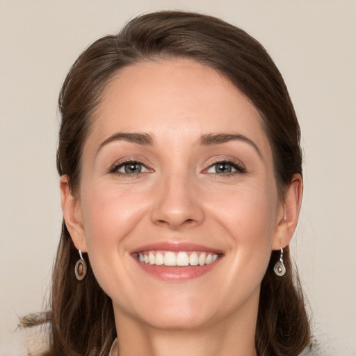 Joyful white young-adult female with long  brown hair and grey eyes