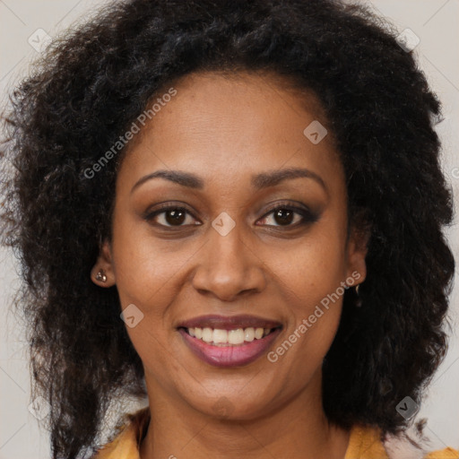 Joyful black young-adult female with long  brown hair and brown eyes