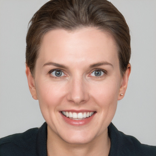 Joyful white young-adult female with short  brown hair and grey eyes