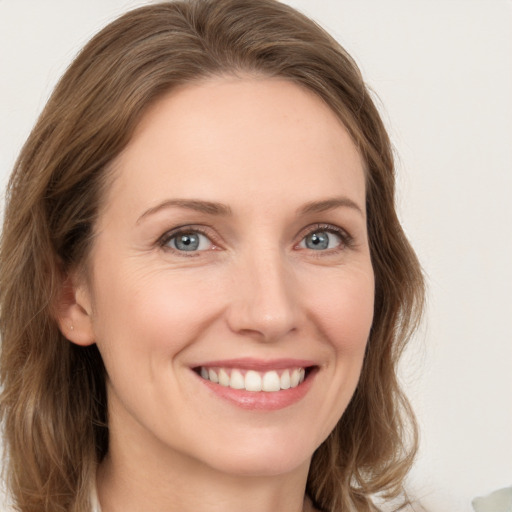 Joyful white young-adult female with long  brown hair and grey eyes