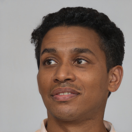 Joyful black young-adult male with short  black hair and brown eyes