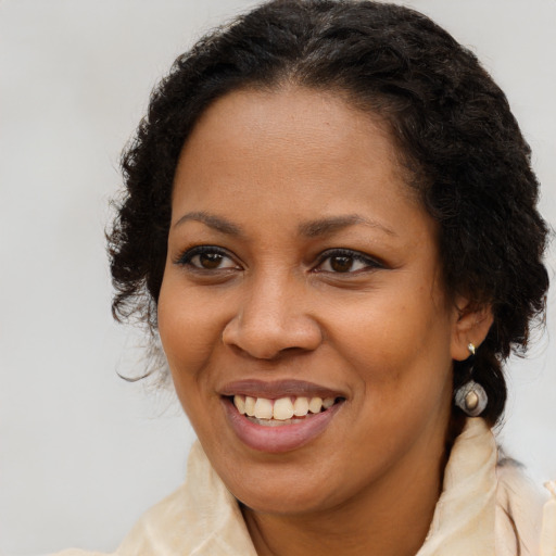 Joyful black young-adult female with long  brown hair and brown eyes