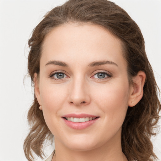 Joyful white young-adult female with medium  brown hair and grey eyes