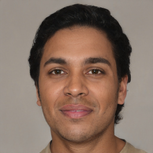 Joyful latino young-adult male with short  black hair and brown eyes