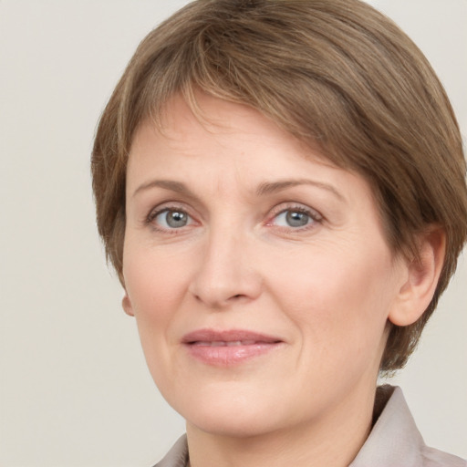 Joyful white adult female with short  brown hair and grey eyes