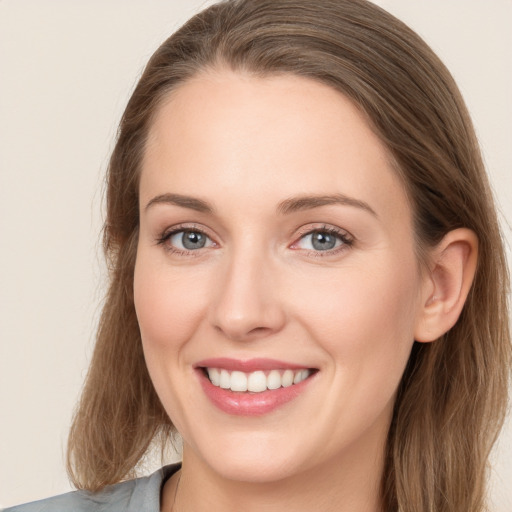 Joyful white young-adult female with long  brown hair and grey eyes