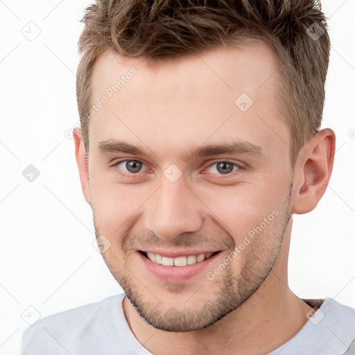 Joyful white young-adult male with short  brown hair and grey eyes