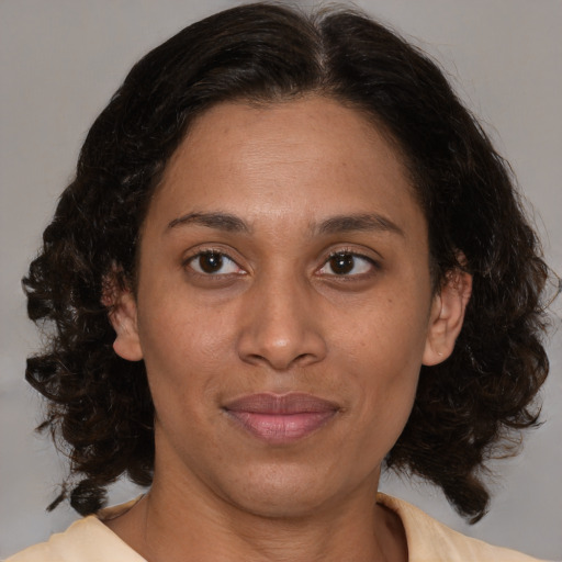 Joyful latino adult female with medium  brown hair and brown eyes