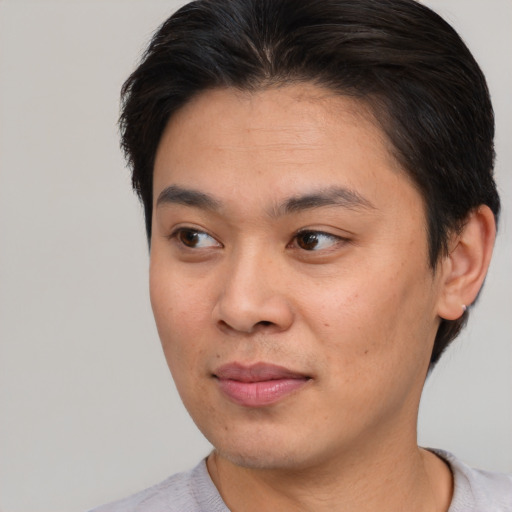 Joyful asian young-adult male with short  brown hair and brown eyes