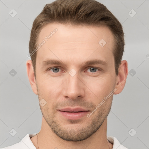 Joyful white young-adult male with short  brown hair and grey eyes