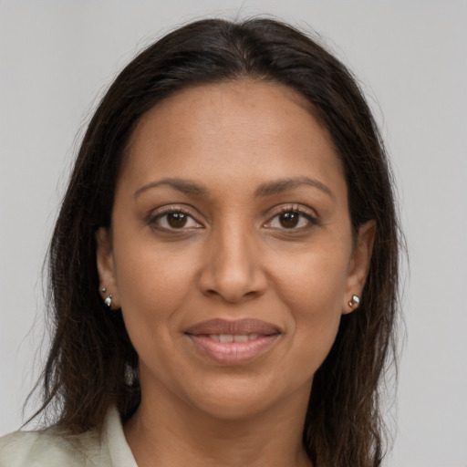 Joyful black young-adult female with long  brown hair and brown eyes