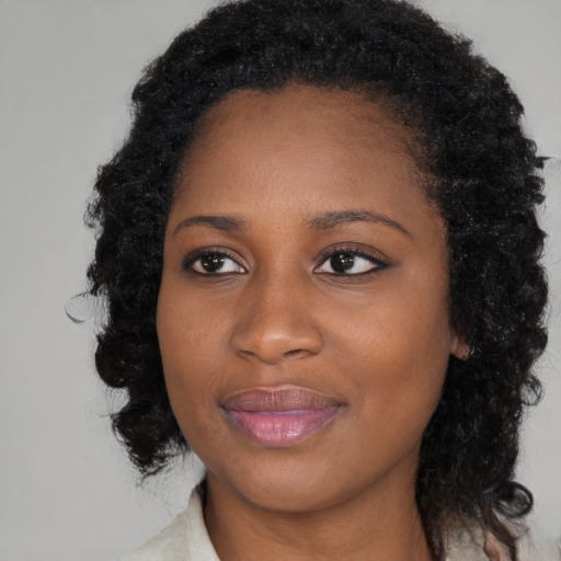Joyful black young-adult female with medium  black hair and brown eyes