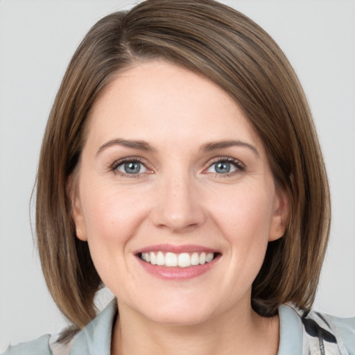 Joyful white young-adult female with medium  brown hair and grey eyes