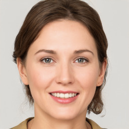 Joyful white young-adult female with medium  brown hair and grey eyes