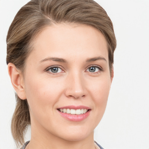 Joyful white young-adult female with medium  brown hair and grey eyes