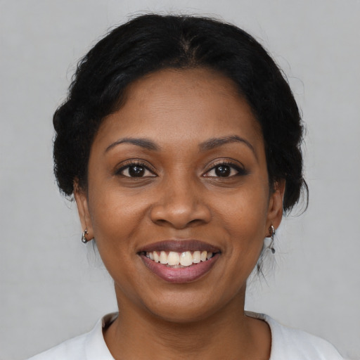 Joyful black young-adult female with medium  brown hair and brown eyes