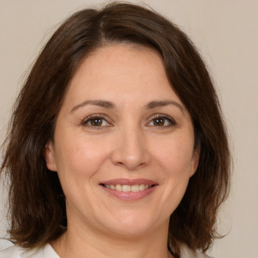 Joyful white adult female with medium  brown hair and brown eyes