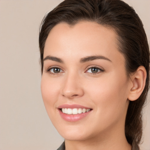 Joyful white young-adult female with long  brown hair and brown eyes