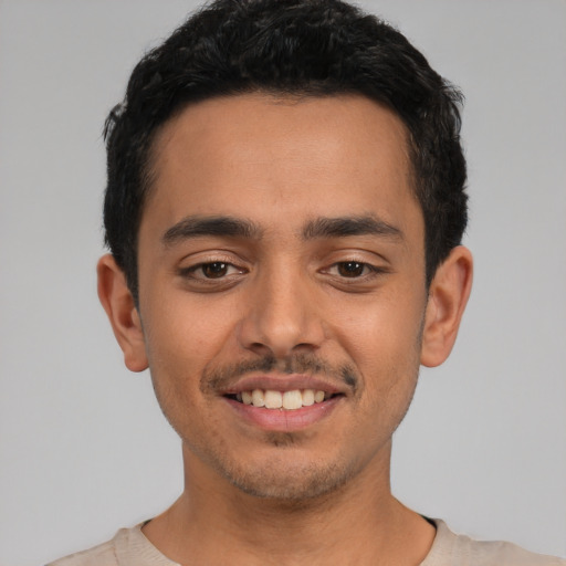 Joyful latino young-adult male with short  black hair and brown eyes