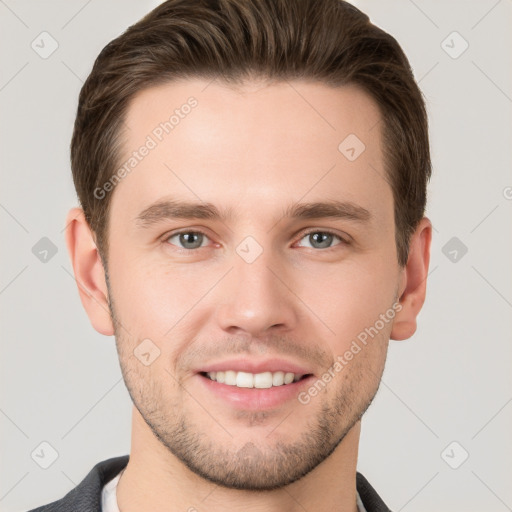 Joyful white young-adult male with short  brown hair and grey eyes