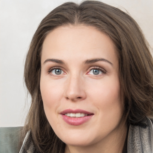 Joyful white young-adult female with long  brown hair and grey eyes